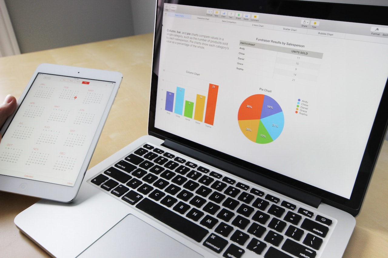 An image of a laptop showing a screen with financial management statistics. 